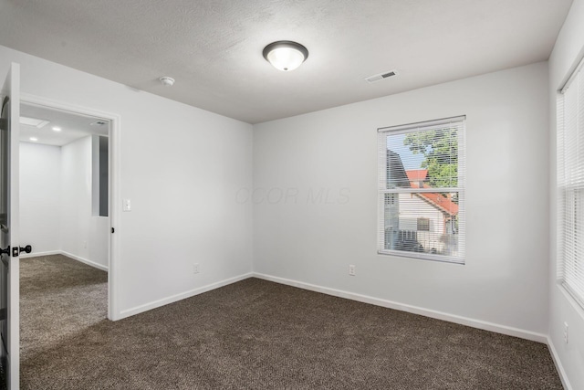 carpeted spare room featuring a textured ceiling