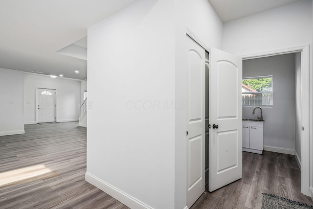 hall with hardwood / wood-style flooring and sink