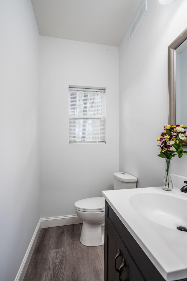 bathroom with hardwood / wood-style flooring, vanity, and toilet