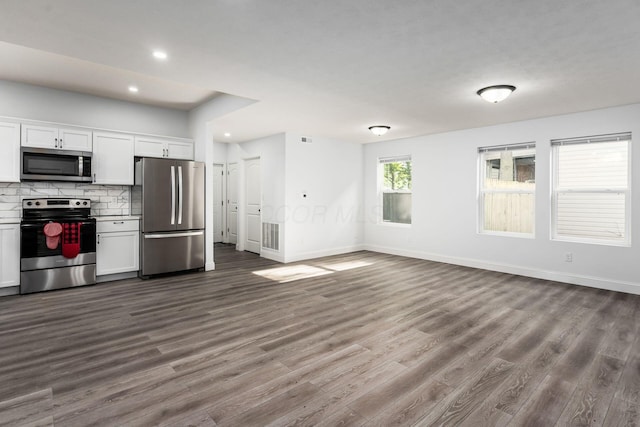 kitchen featuring stainless steel appliances, hardwood / wood-style floors, decorative backsplash, and white cabinets