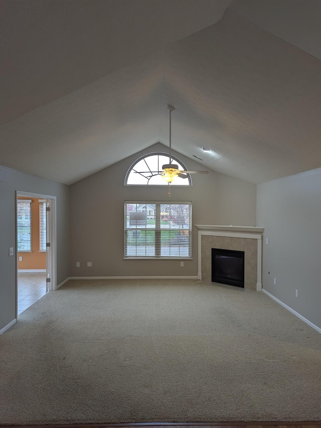 unfurnished living room with a tile fireplace, light colored carpet, ceiling fan, and lofted ceiling