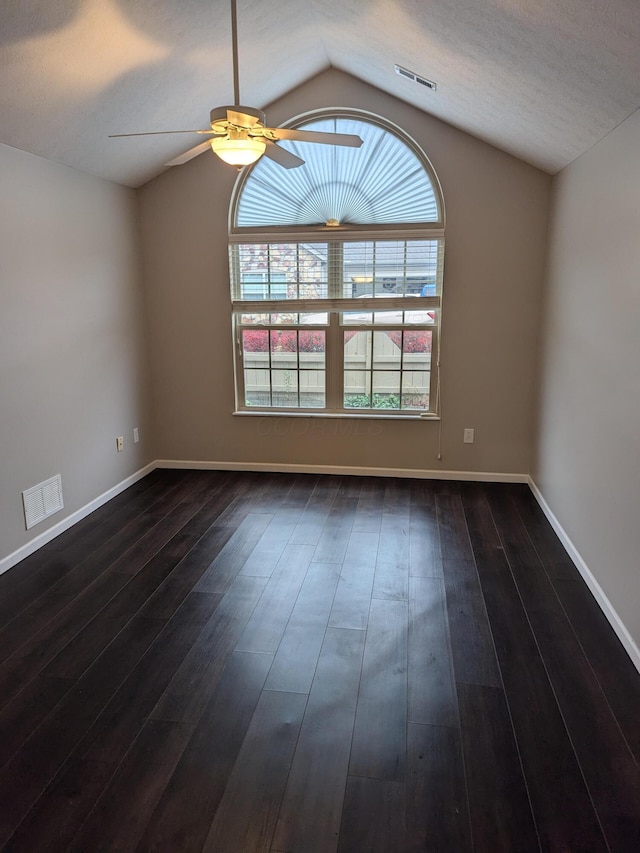 spare room with ceiling fan, dark hardwood / wood-style floors, and vaulted ceiling