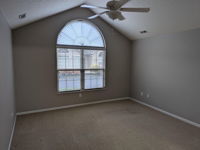 unfurnished room with a textured ceiling, carpet floors, ceiling fan, and lofted ceiling