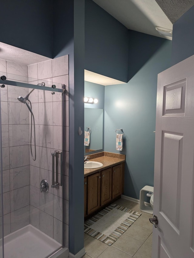 bathroom with walk in shower, tile patterned flooring, a textured ceiling, toilet, and vanity