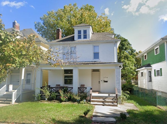 view of front of home with covered porch and a front lawn