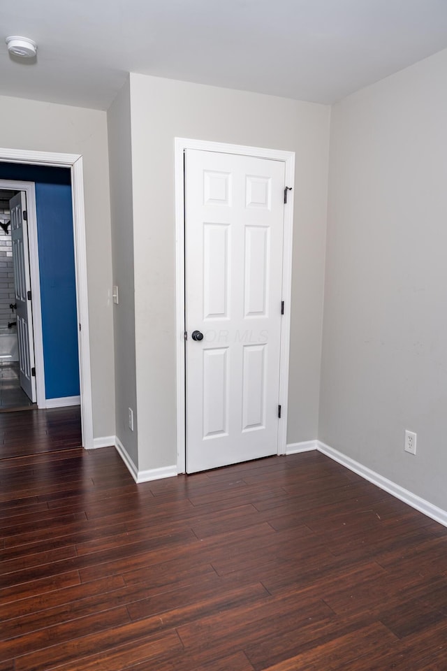 unfurnished bedroom featuring dark hardwood / wood-style flooring