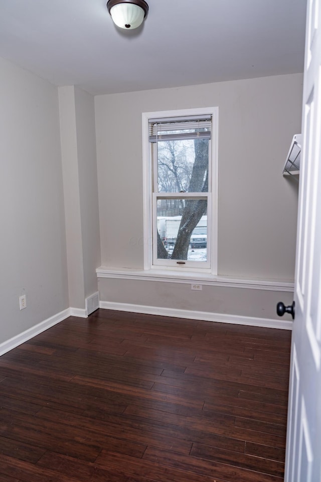 unfurnished room with dark wood-type flooring