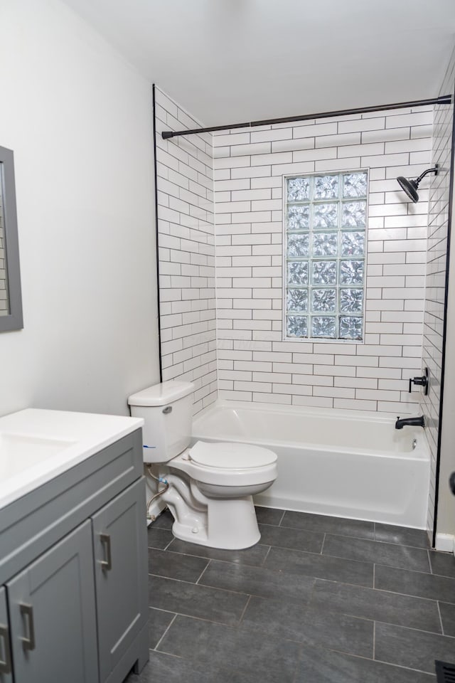 full bathroom with tiled shower / bath combo, toilet, and vanity