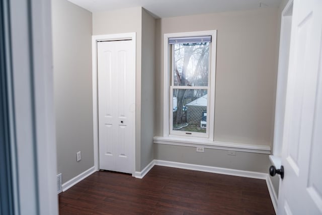 unfurnished bedroom featuring dark hardwood / wood-style floors and a closet