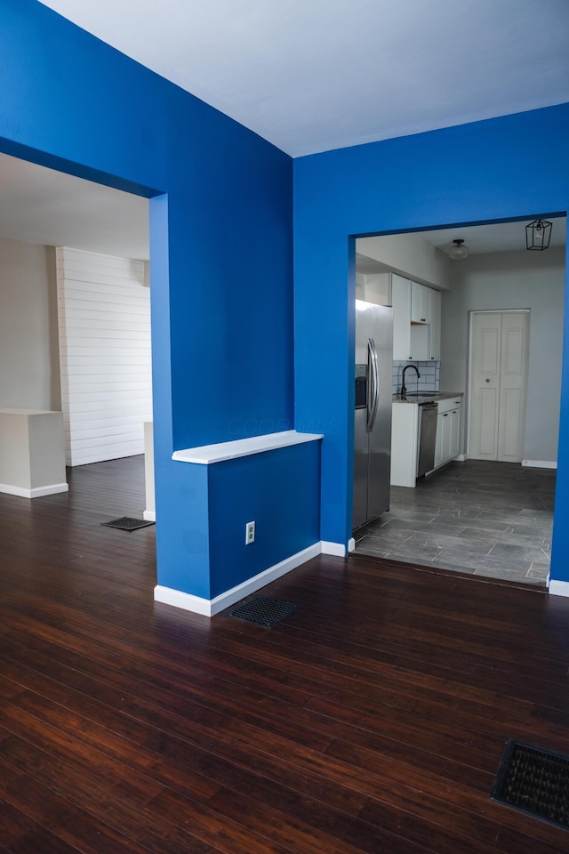 spare room featuring sink and dark hardwood / wood-style flooring