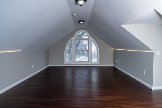 bonus room with dark hardwood / wood-style floors and vaulted ceiling