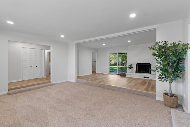 unfurnished living room featuring light colored carpet and a fireplace