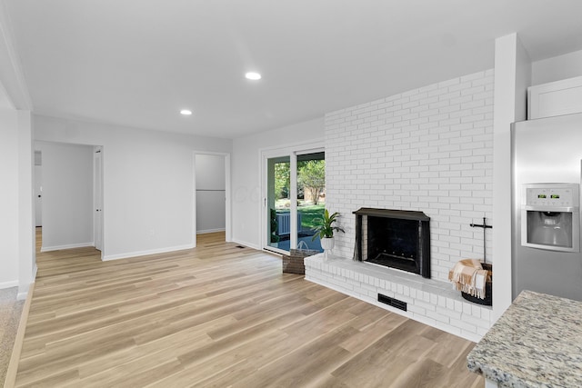 living room with a fireplace and light hardwood / wood-style floors