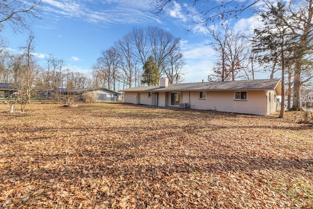 back of house with central AC unit