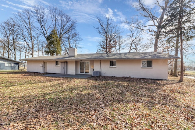 rear view of house featuring central AC unit, a lawn, and a patio