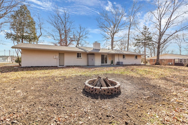 back of house with an outdoor fire pit and central AC unit