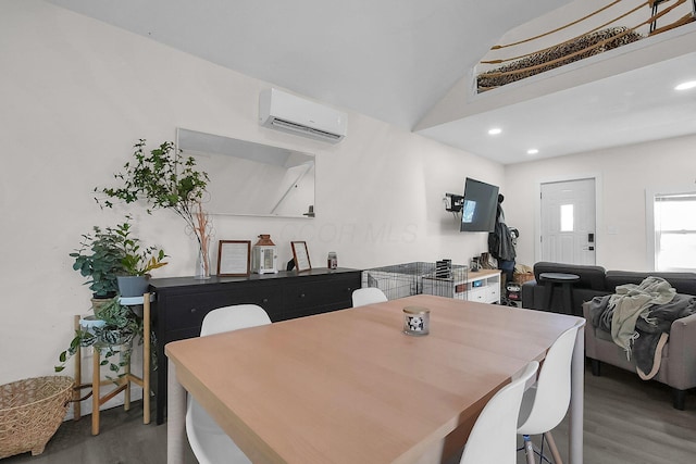 dining room with vaulted ceiling, wood-type flooring, and a wall mounted air conditioner