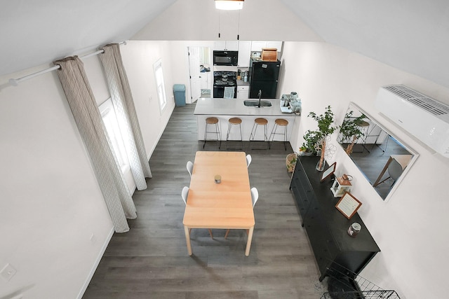 living room with a wall unit AC, dark wood-type flooring, and sink