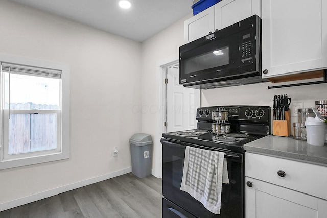 kitchen featuring white cabinetry, light hardwood / wood-style flooring, and black appliances