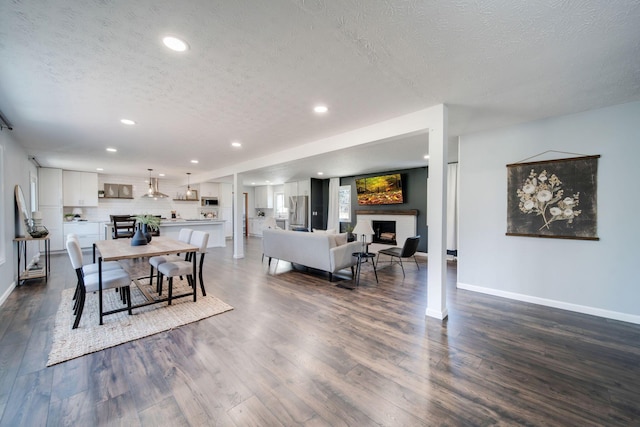 dining space featuring a textured ceiling and dark wood-type flooring