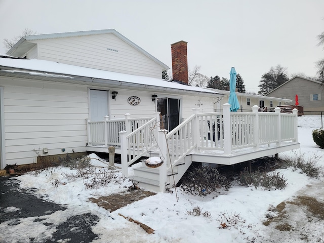 snow covered house with a deck