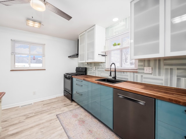 kitchen featuring stainless steel dishwasher, black gas range oven, ceiling fan, sink, and butcher block countertops