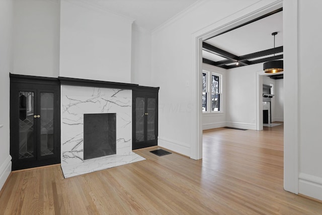 interior space with ornamental molding, coffered ceiling, hardwood / wood-style flooring, a premium fireplace, and beamed ceiling