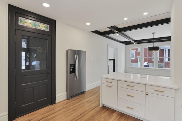 kitchen featuring stainless steel fridge with ice dispenser, light stone counters, pendant lighting, white cabinets, and light wood-type flooring