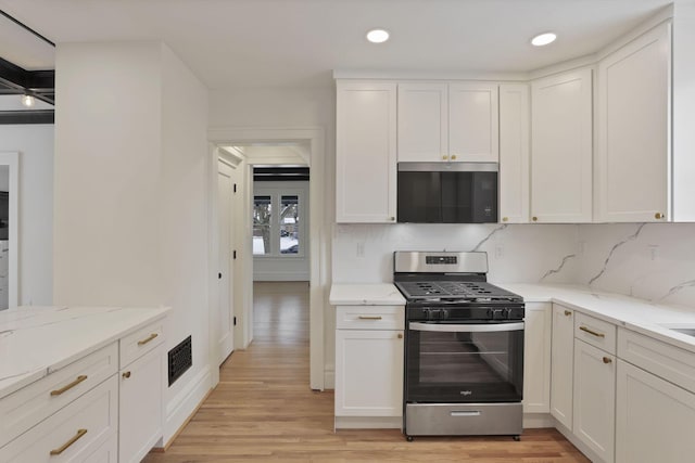 kitchen featuring stainless steel gas stove and white cabinets