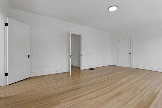 spare room with light hardwood / wood-style floors and ornamental molding