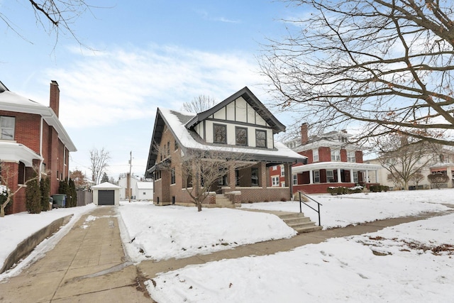 view of front of house with covered porch, a garage, and an outdoor structure