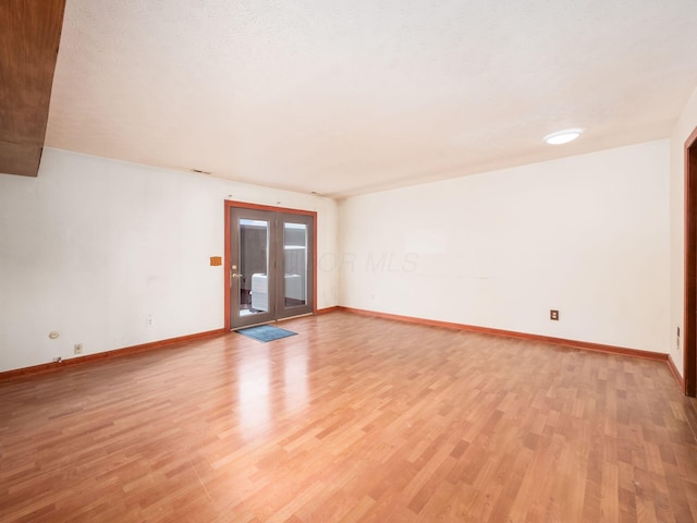 unfurnished room featuring french doors and light hardwood / wood-style floors