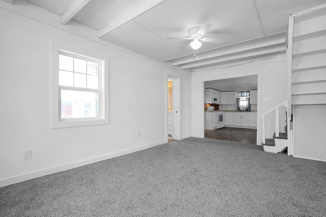 unfurnished living room with ceiling fan, dark carpet, and sink