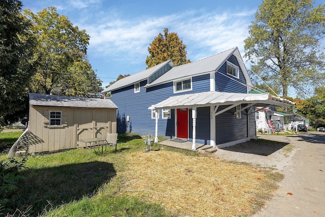 view of front of home with a shed and a front lawn