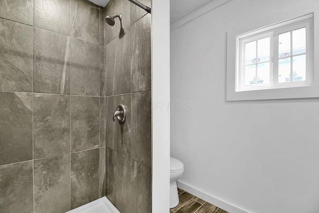 bathroom featuring a tile shower and toilet