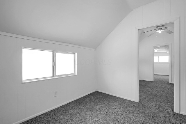 additional living space featuring ceiling fan, dark carpet, and vaulted ceiling