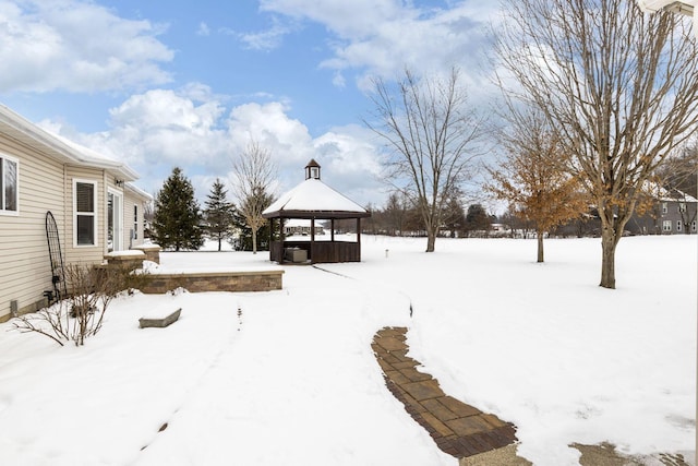 snowy yard featuring a jacuzzi and a gazebo