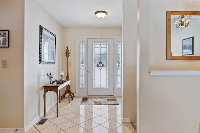 tiled foyer with a notable chandelier and a healthy amount of sunlight