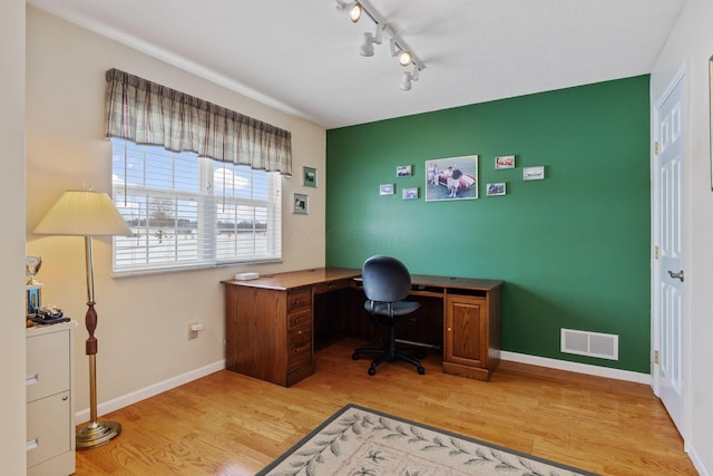 home office with light hardwood / wood-style floors