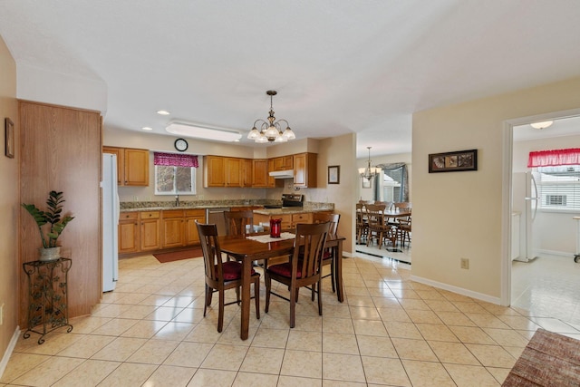 dining room featuring sink, a notable chandelier, and light tile patterned flooring