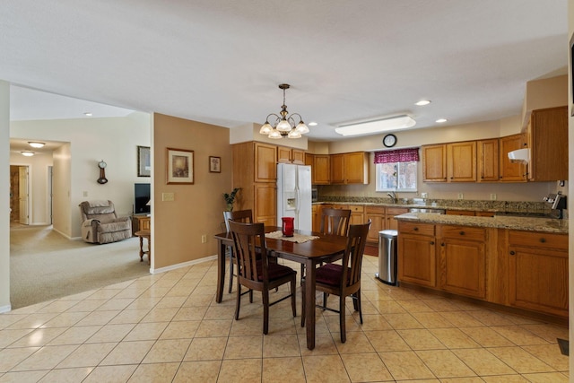 dining area with light carpet, sink, and a notable chandelier