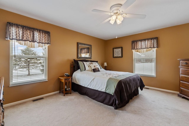 bedroom featuring multiple windows, light colored carpet, and ceiling fan