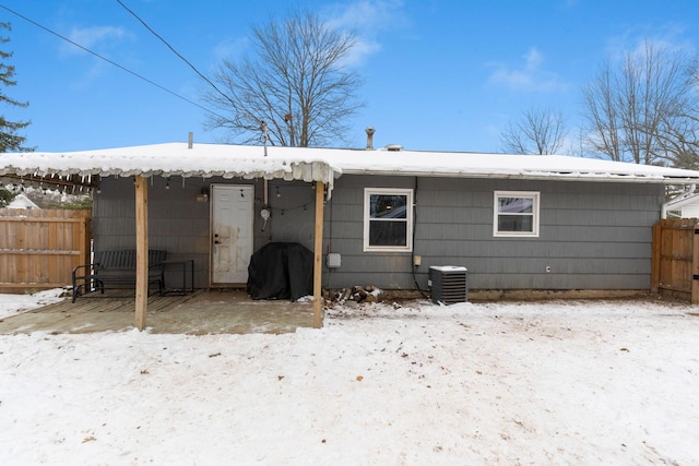 snow covered property featuring central AC