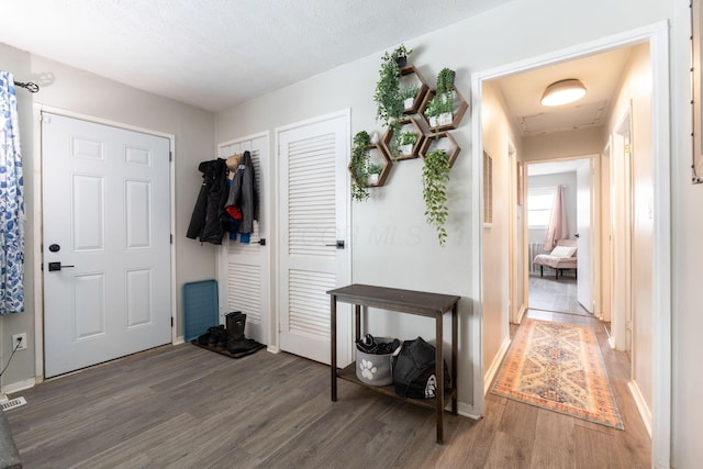 entrance foyer with a textured ceiling and dark hardwood / wood-style floors