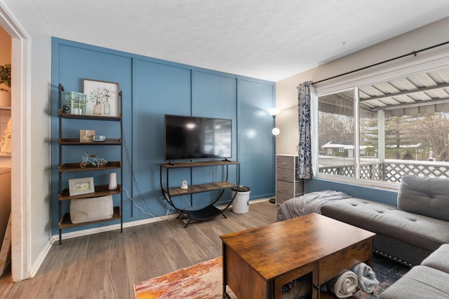 living room with a textured ceiling and dark wood-type flooring