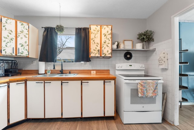 kitchen featuring white cabinetry, tasteful backsplash, range with electric cooktop, and sink