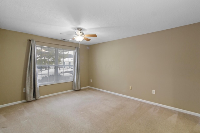 carpeted spare room with ceiling fan and a textured ceiling