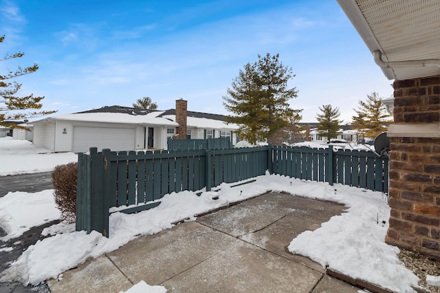 snow covered patio with a garage