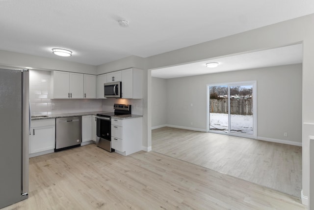 kitchen featuring white cabinets, appliances with stainless steel finishes, tasteful backsplash, and light hardwood / wood-style floors