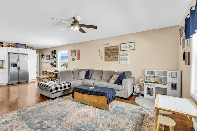 living room featuring ceiling fan and hardwood / wood-style flooring